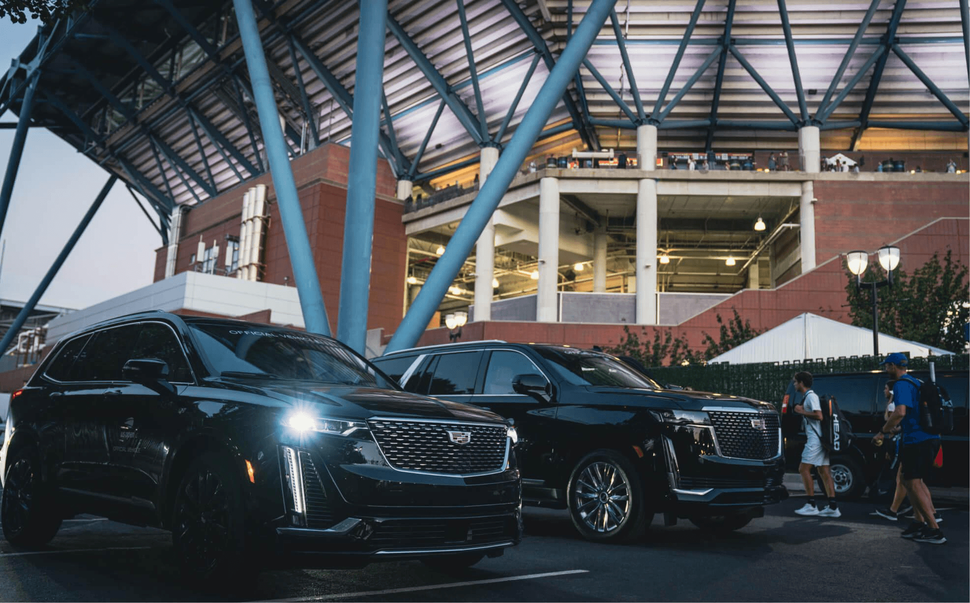 Chauffeur waiting by SUV for stadium transfer
